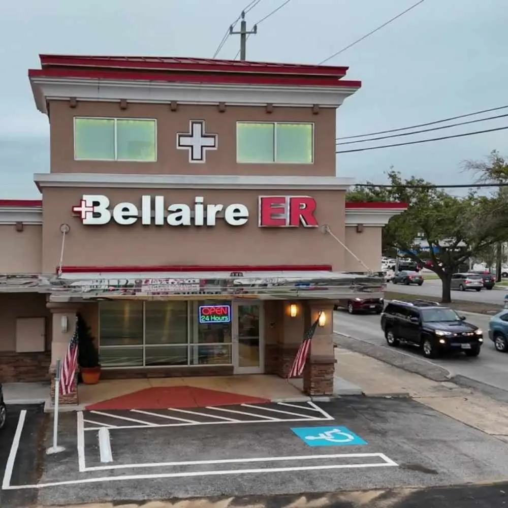 Bellaire ER facility with Open 24 Hours sign and American flags at the entrance